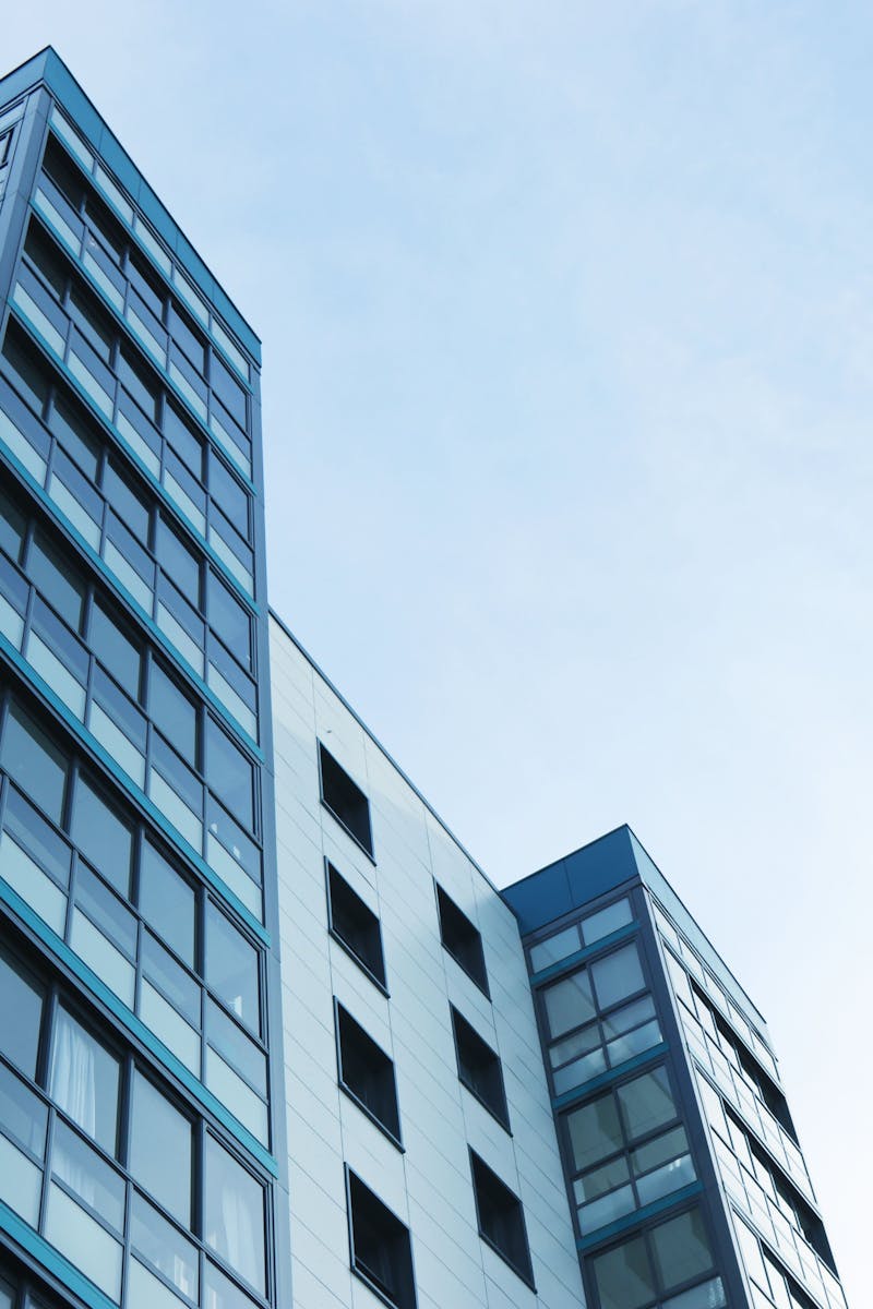 Low-angle view of a modern glass skyscraper against a clear sky in Poole, UK.